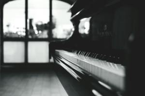 Close-up of a piano keyboard with a blurred background of an interior setting.